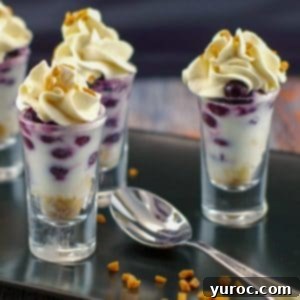saskatoon berry dessert shooters on a black tray with a spoon