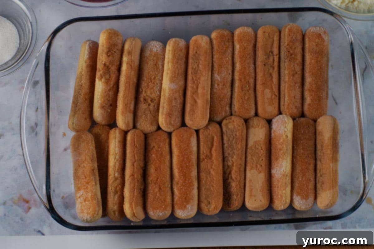 Layer of lady fingers with coffee and Kahlua drizzled on, in the bottom of a glass 9x13 pan.