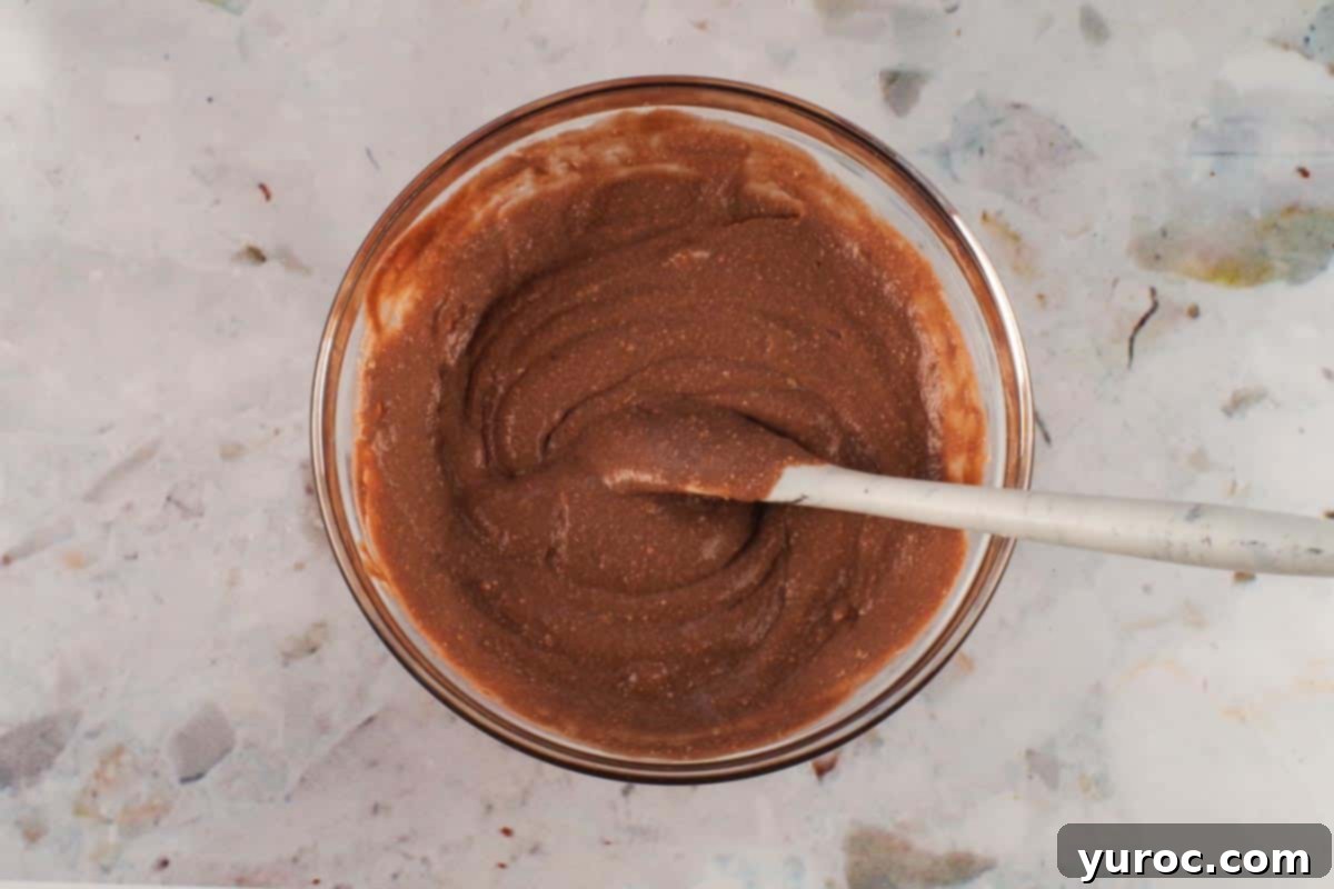 Chocolate Pudding and Mascarpone Cheese mixed together in a medium glass bowl.