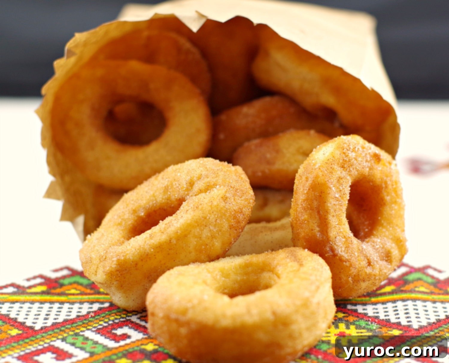 Close-up of golden brown Pampushky, mini Ukrainian doughnuts, dusted with cinnamon sugar, ready to be enjoyed.