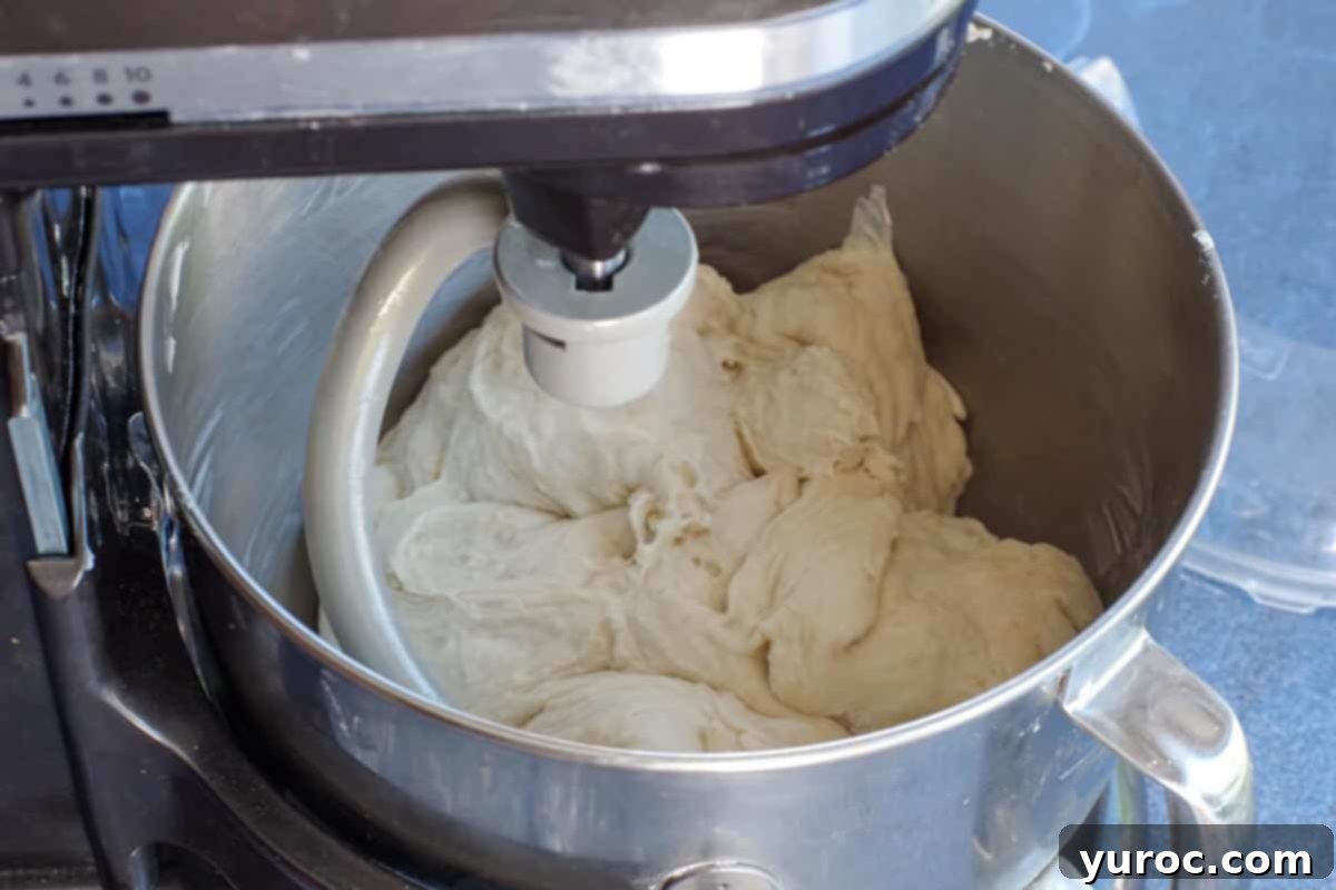 Dough being kneaded in a stand mixer with a dough hook attachment.