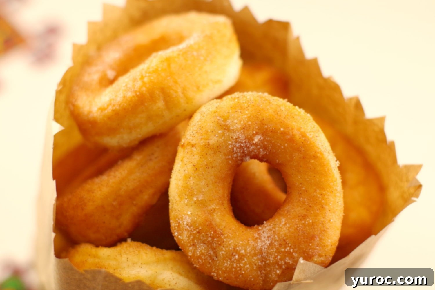 A stack of golden Pampushky, mini Ukrainian doughnuts, on a plate, enjoyed Stampede-style.