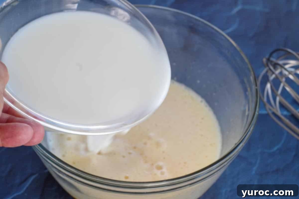 Milk being added to the lightened egg and oil mixture.
