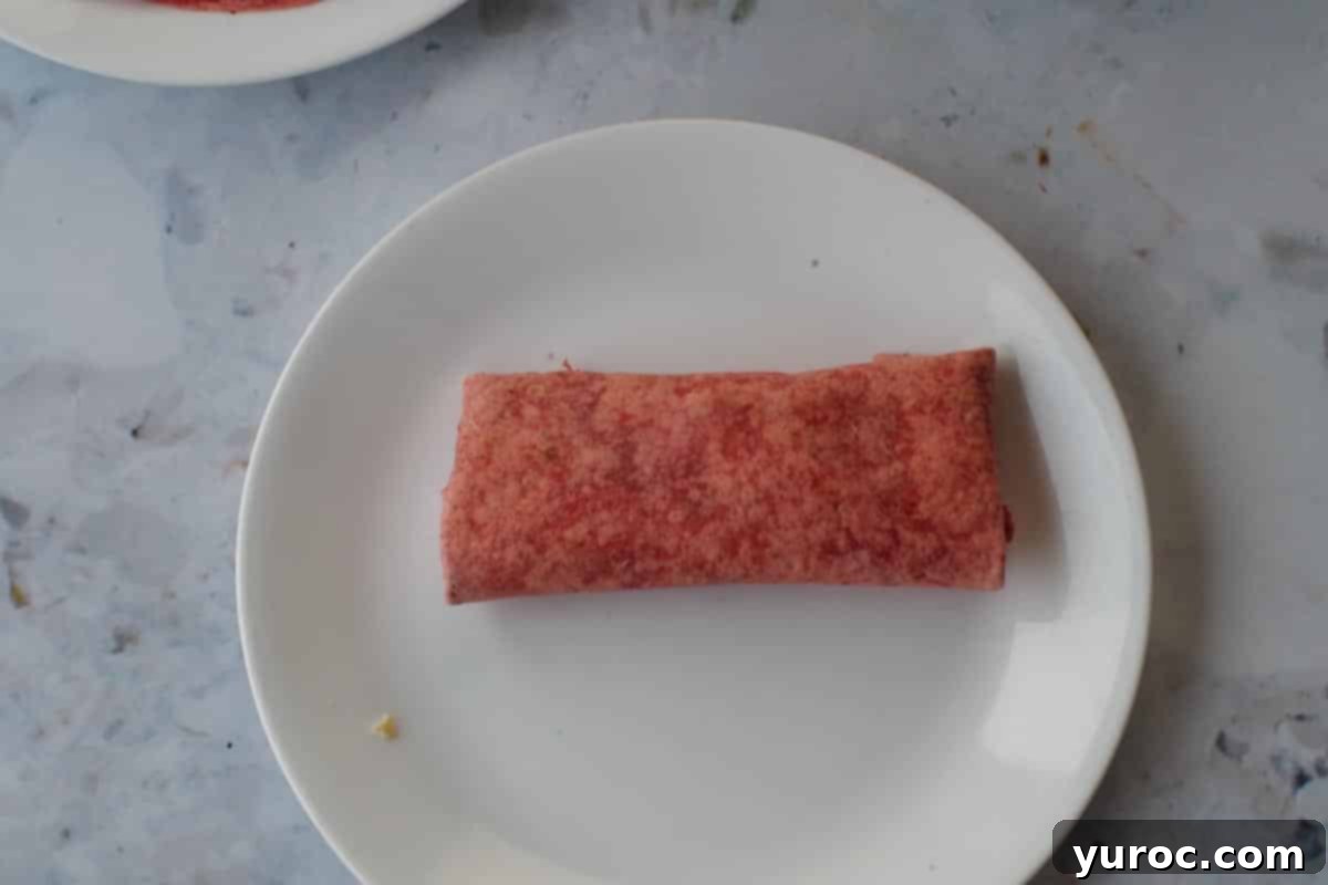 Breakfast burrito flipped over with folds on the bottom.
