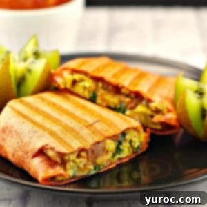 breakfast burrito on a black plate,. cut in half