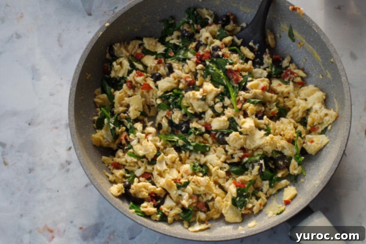 Egg mixture (with sun-dried tomatoes, olives and spinach ) no longer "wet" in frying pan.