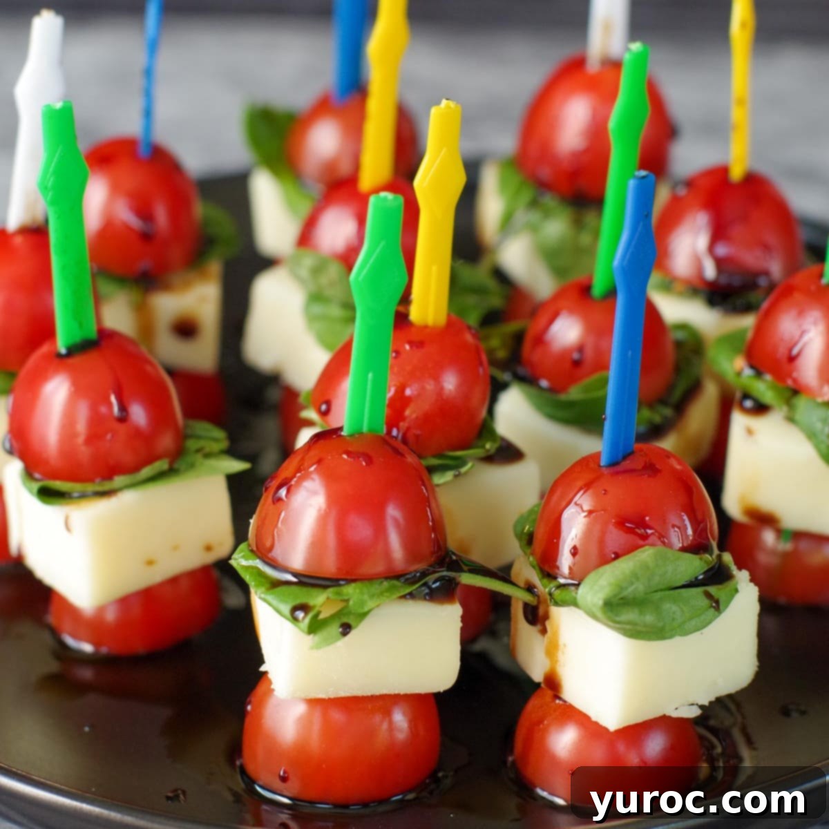 caprese bites on a black platter