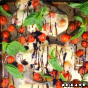 Sheet pan Caprese Chicken on sheet pan with basil and grape tomatoes