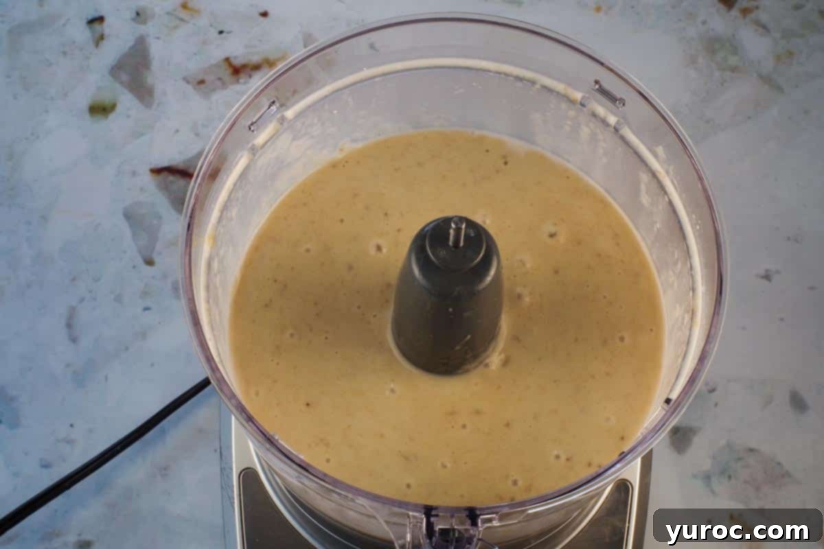 Nice cream ingredients thoroughly blended to a smooth, thick, and creamy soft-serve consistency in the food processor.