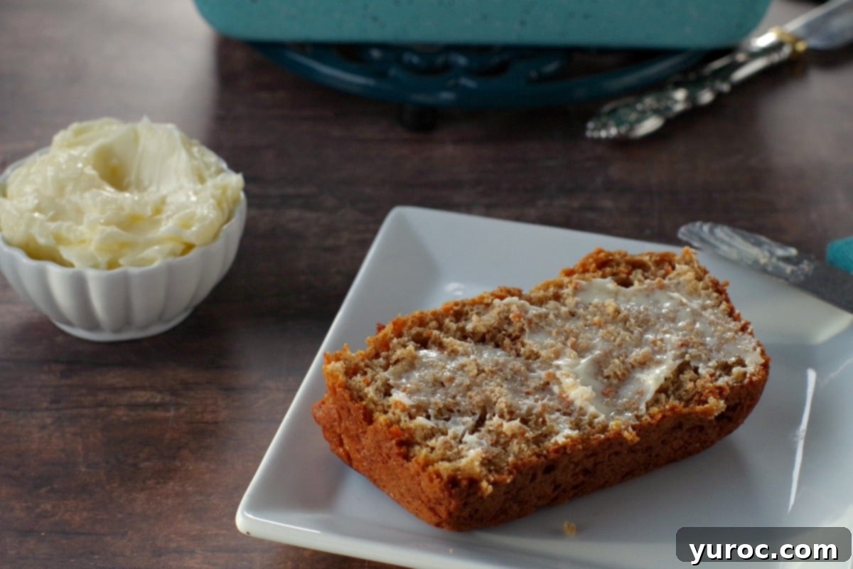 healthy carrot loaf slice with butter on a white plate with white dish of butter in the background