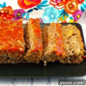 meatloaf, sliced on a black tray with a colorful flower tea towel in the background