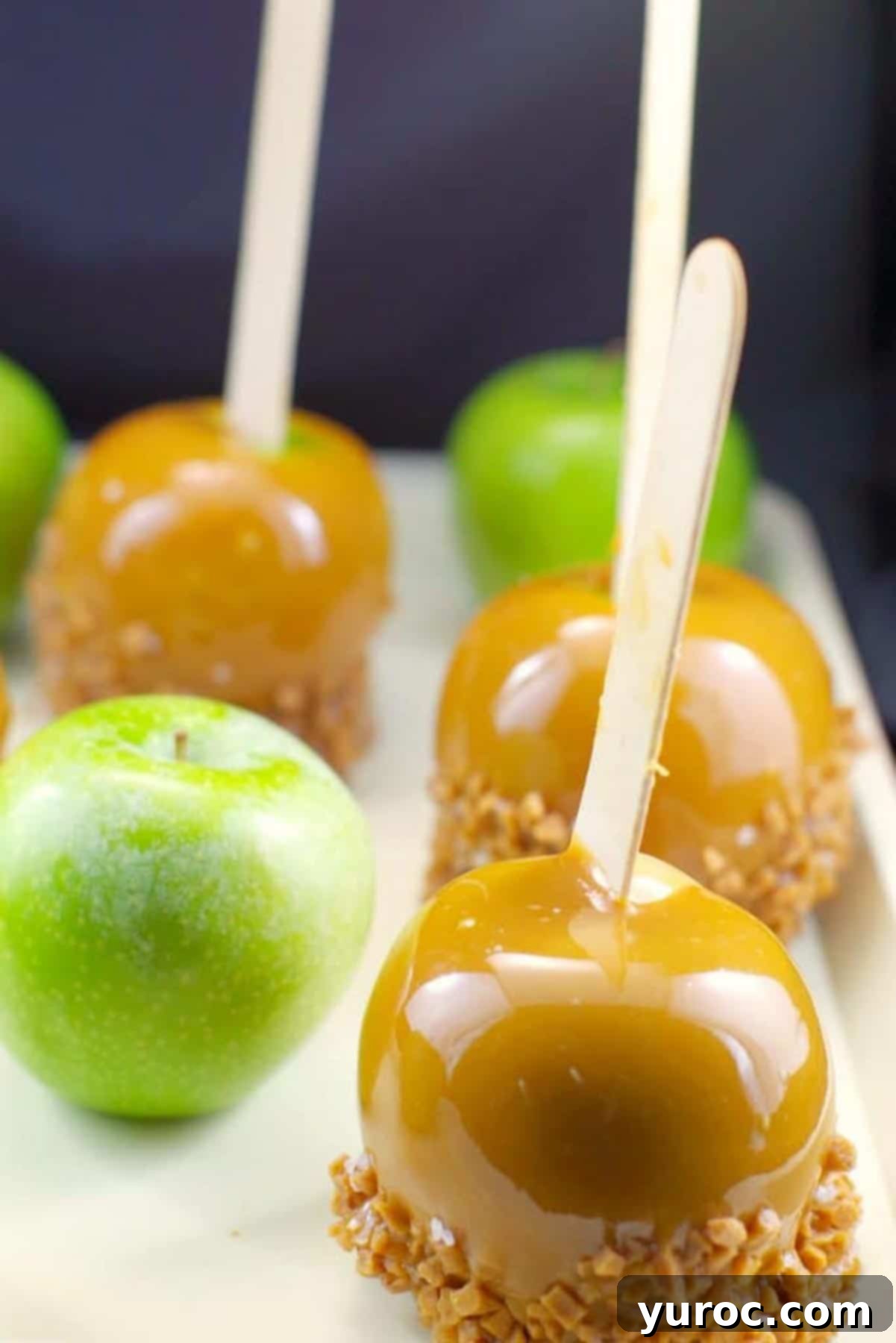 green and caramel apples on a beige tray