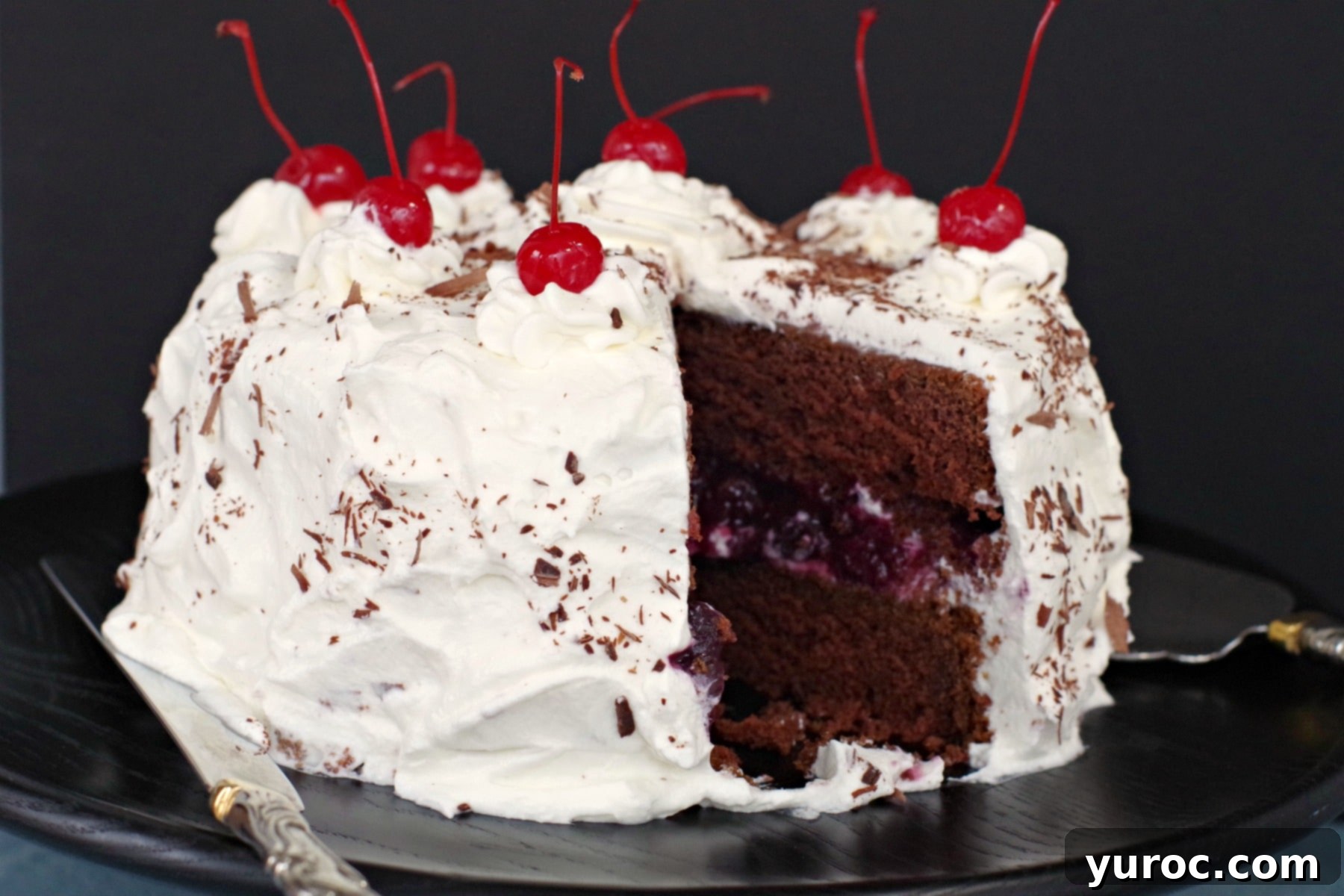 Quick and Easy Black Forest Cake 5 Homemade Black Forest cake with one slice removed, revealing the delicious layers of chocolate cake, cherry filling, and whipped cream.