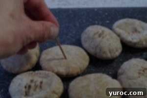 poking a hole in mini pita bread with a toothpick
