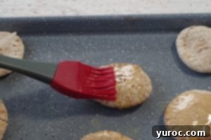 melted butter being spread on a mini pita with a pastry brush