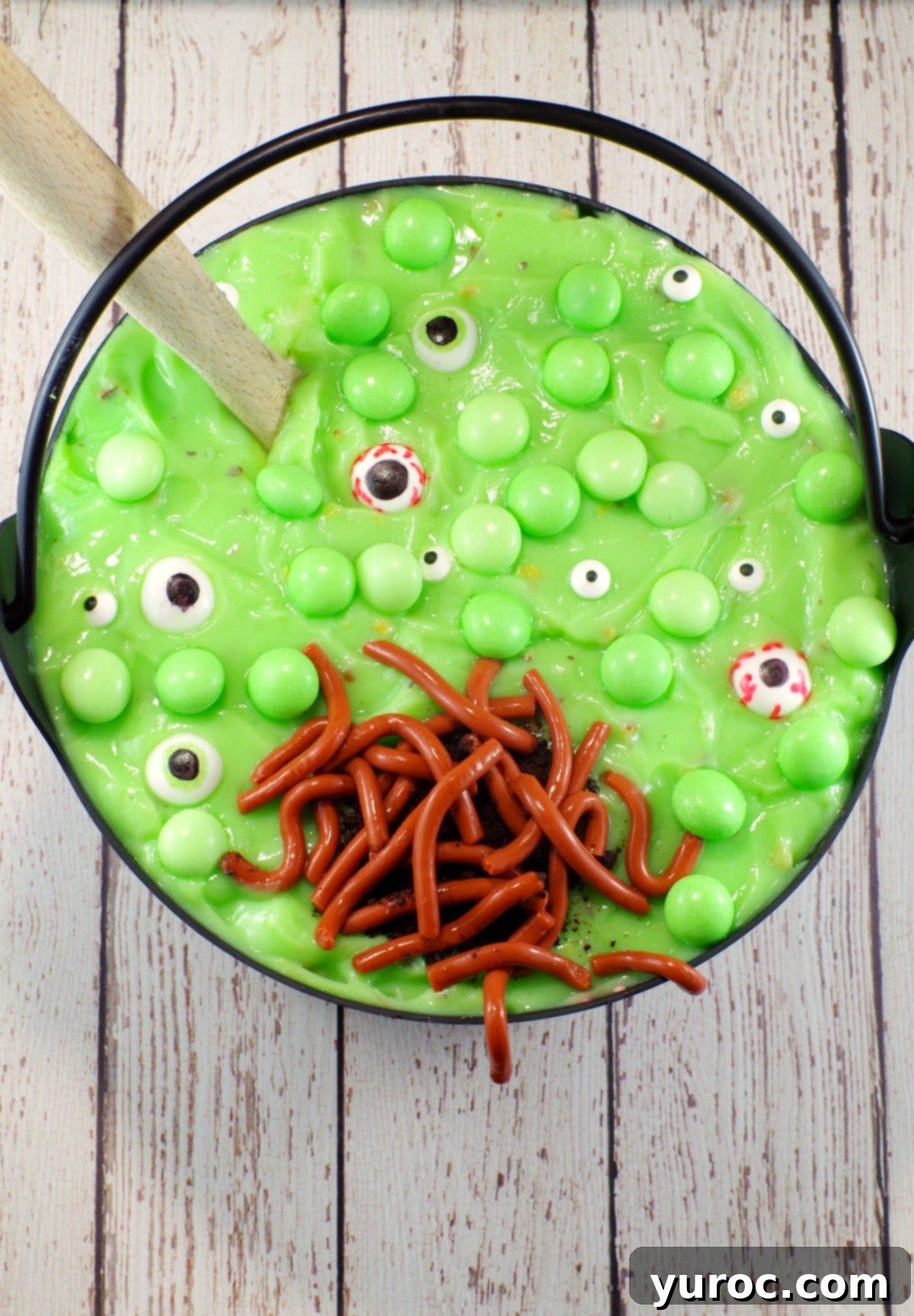 Spooky Swamp Trifle with Wriggling Worms 4 Close-up of the Witches Brew Halloween Trifle showcasing the green pudding, red cherry filling, and whipped cream layers, topped with edible mint eyeballs and Jello worms.