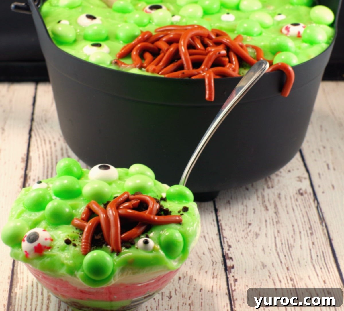 Spooky Swamp Trifle with Wriggling Worms 5 Individual Witches Brew Spumoni trifles in mini cauldrons, showcasing layers of green, red, and cream, topped with Jello worms and candy eyes.