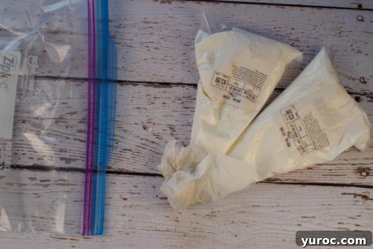 Two pastry bags filled with royal icing, with a damp paper towel on the end and a large Ziploc bag.