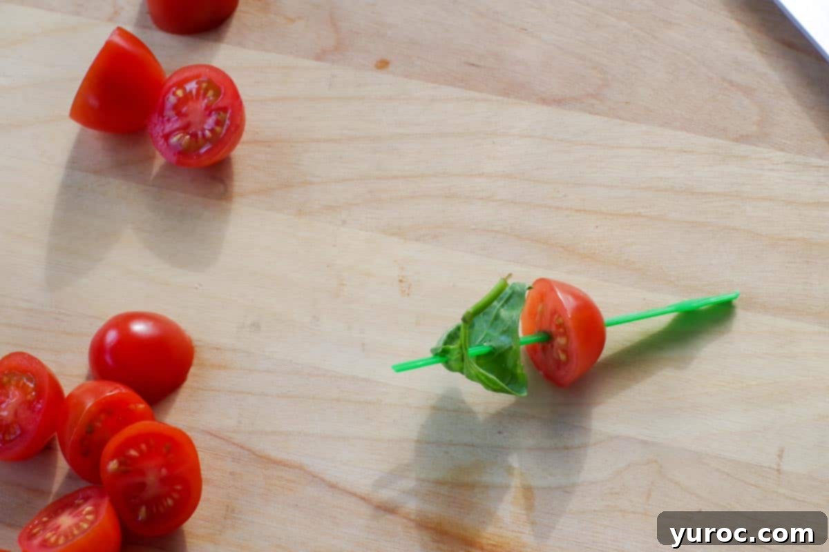 basil added to tomato on skewer