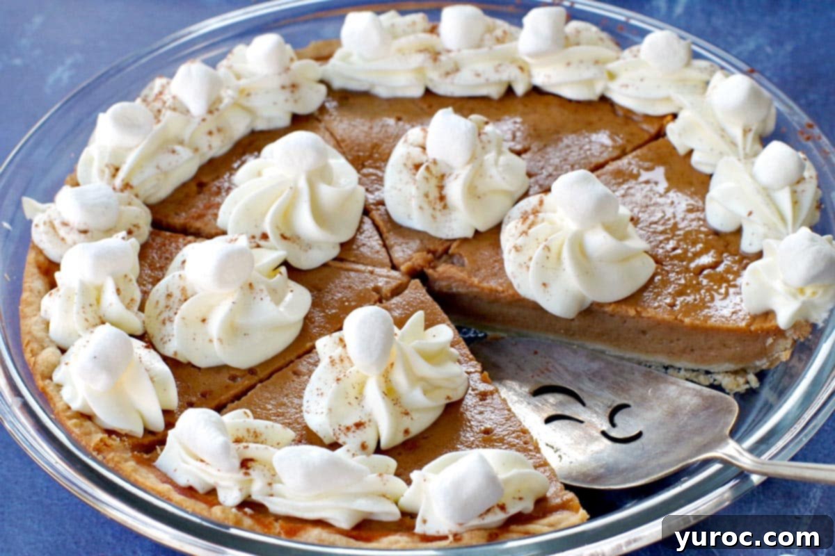 Toasted Marshmallow Sweet Potato Delight 12 Sweet potato pie with marshmallow whipped cream in glass pie plate with piece missing and pie lifter in missing spot.