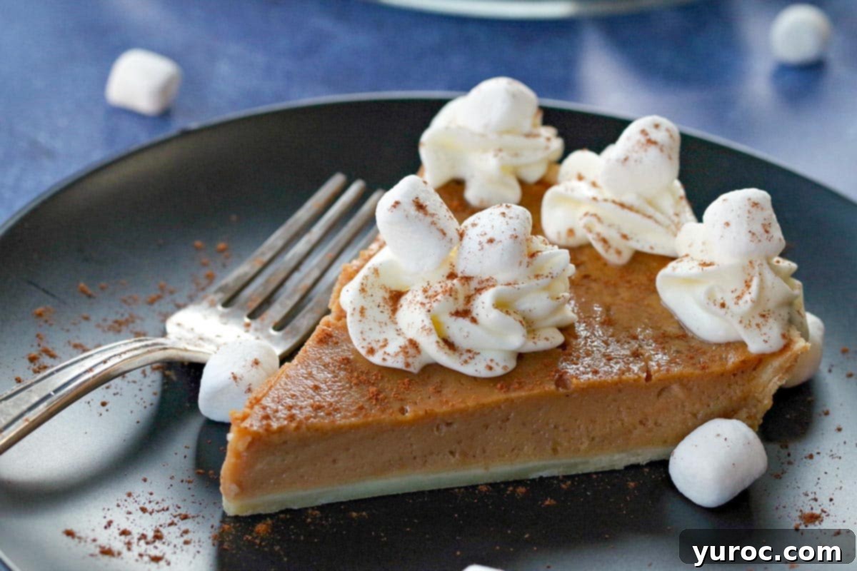 Toasted Marshmallow Sweet Potato Delight 15 Sweet potato pie on black plate on blue background with marshmallows around and pie in the background.