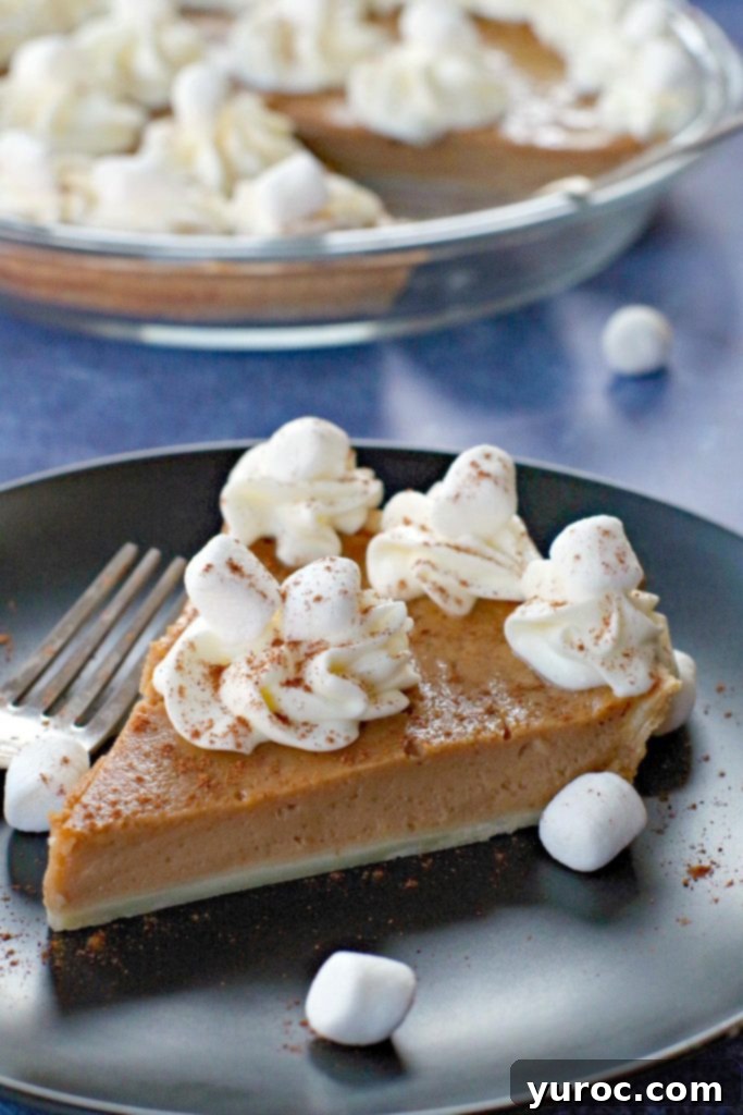 Toasted Marshmallow Sweet Potato Delight 16 sweet potato pie on black plate on blue background with marshmallows around and pie in background