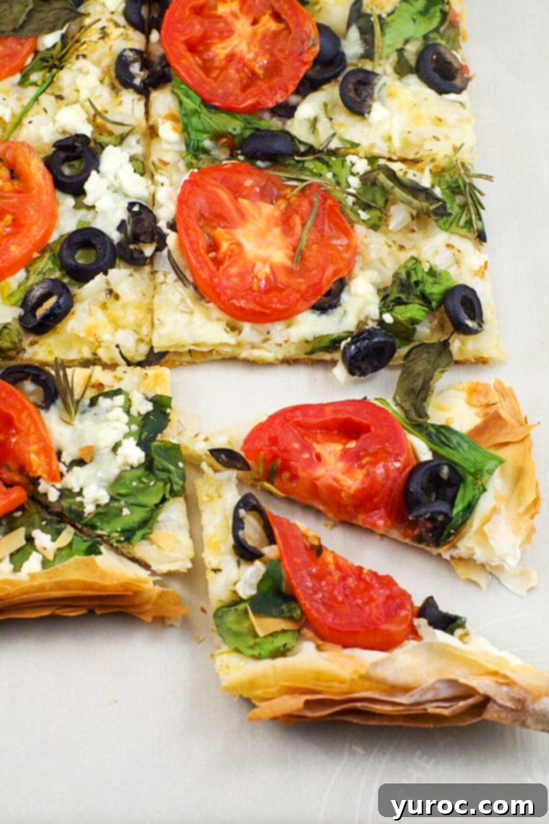 Greek Phyllo Vegetable Tart 7 Filo Pastry pizza cut into triangles, with a couple of pieces sticking out, ready to be served.