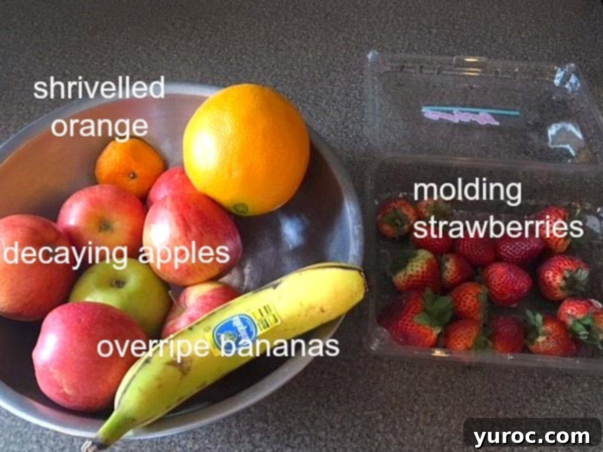 overripe fruit in a bowl and spoiling strawberries in plastic container on counter