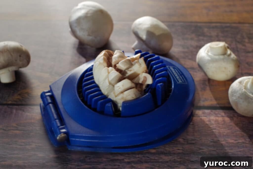 mushroom in egg slicer with whole mushrooms in the background