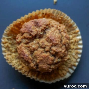 15 Deliciously Healthy Bran Muffin Recipes 15 A delectable butternut squash bran muffin, with its wrapper elegantly peeled off, resting delicately on the wrapper itself, showcasing its moist texture and inviting, rich autumnal color.