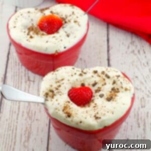 2 heart shaped healthy strawberry chocolate cakes on a white faux wooden surface.