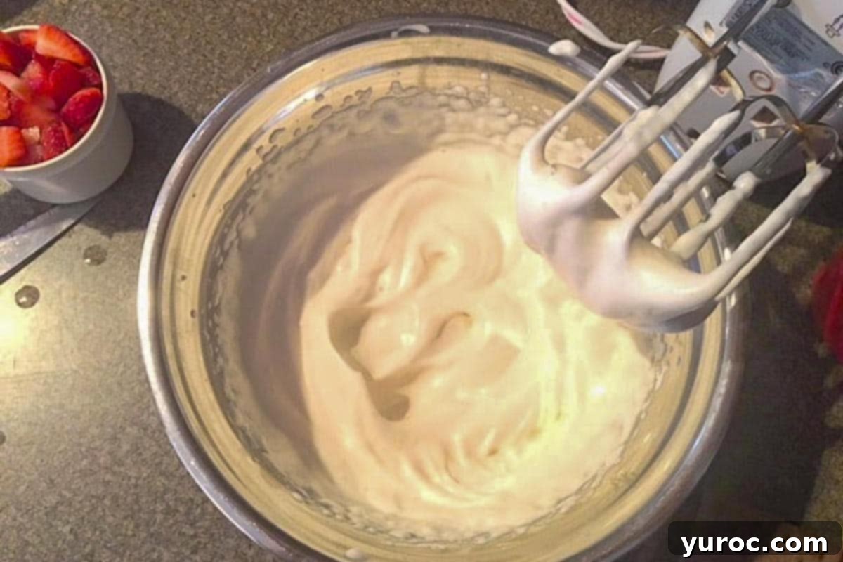 Evaporated milk whipped to stiff peaks in a glass bowl