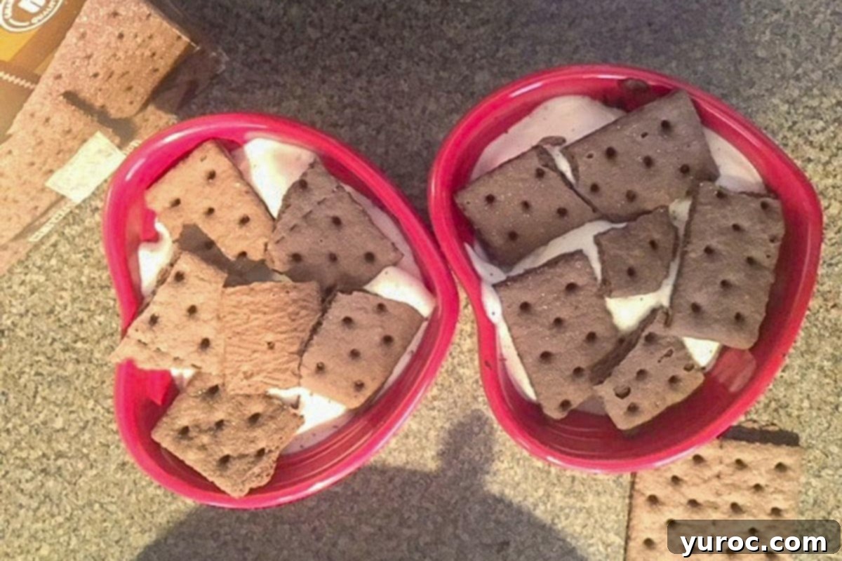 Assembling the icebox cake with strawberry whipped cream and graham crackers