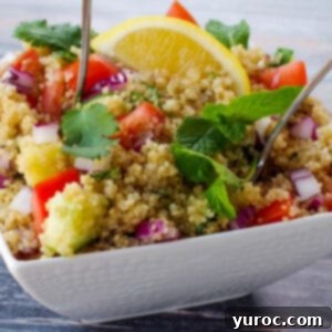 quinoa salad with spoon sticking out, in white bowl