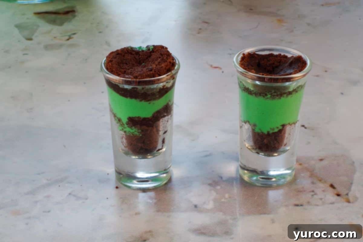 St. Patrick's Day Shamrock Irish Cream Shots 14 Brownie pressed into shot glass on top of the green pudding mixture.