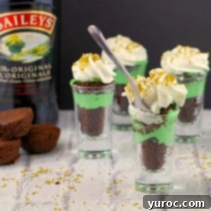 St. Patrick's Day Shamrock Irish Cream Shots 18 Irish cream dessert shots with a bottle of irish cream in the background, on a white faux surface