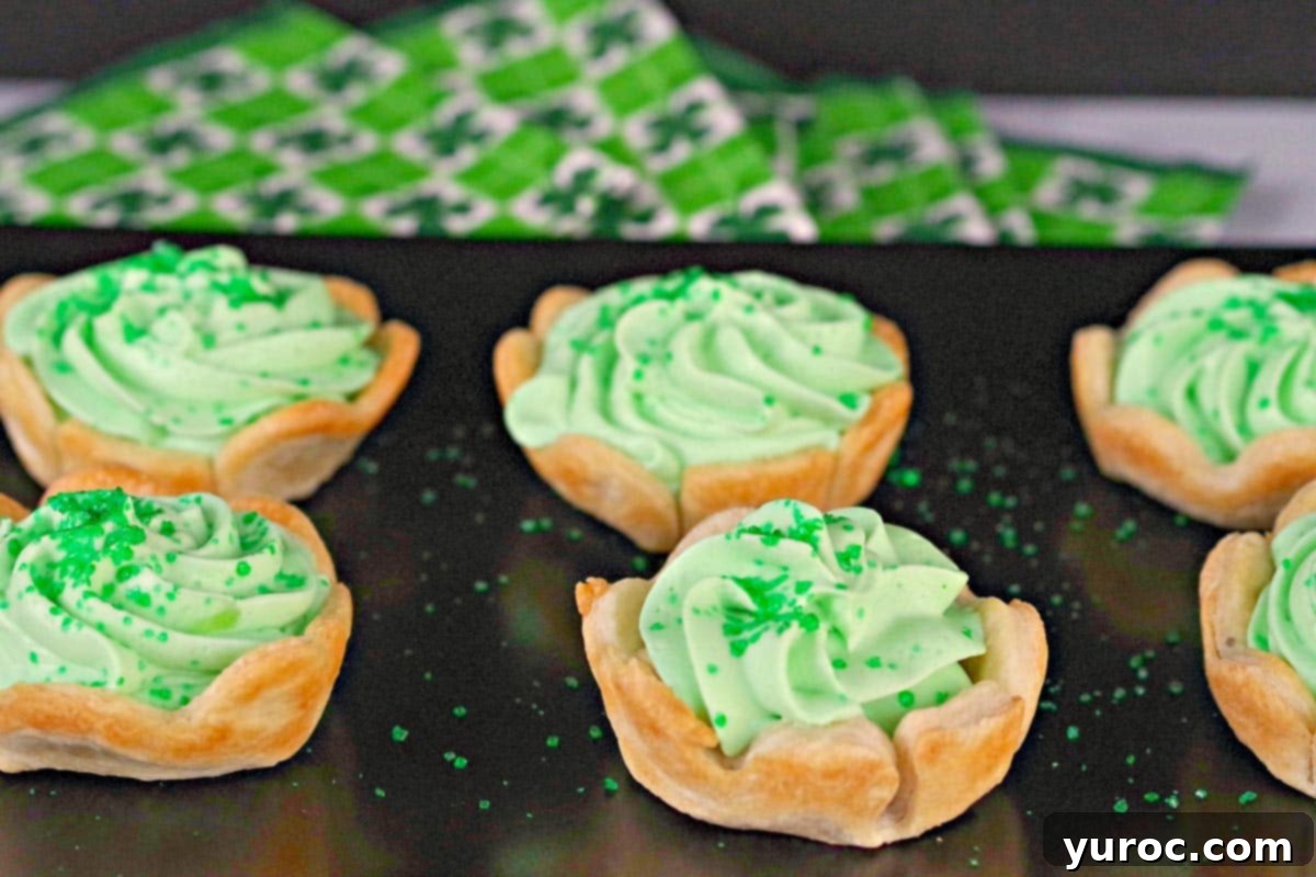 A stunning arrangement of St. Patrick's Day Shamrock Tarts displayed on a chic black tray, perfectly ready for a festive gathering.