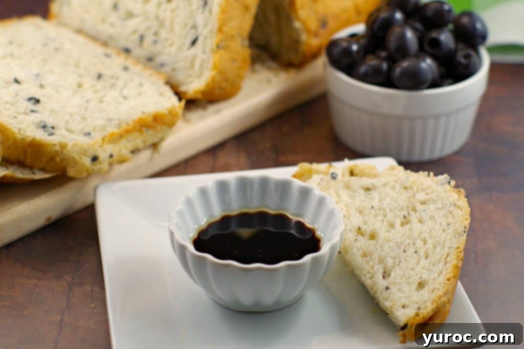 Loaf of Bread Machine Onion and Olive Bread with oil and vinegar in a dish
