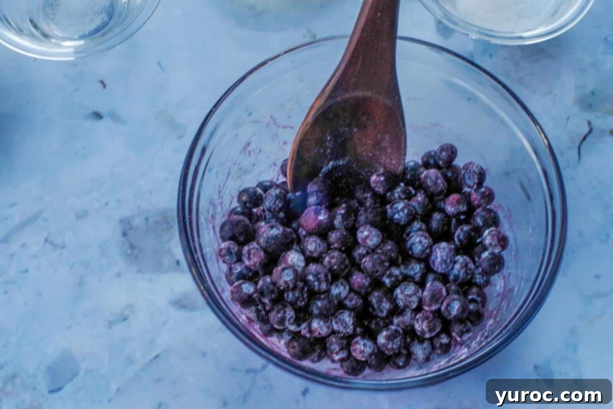 Wholesome Blueberry Cornbread Delight 6 Blueberries lightly coated with flour in a glass bowl, ready to be added to cornbread batter.