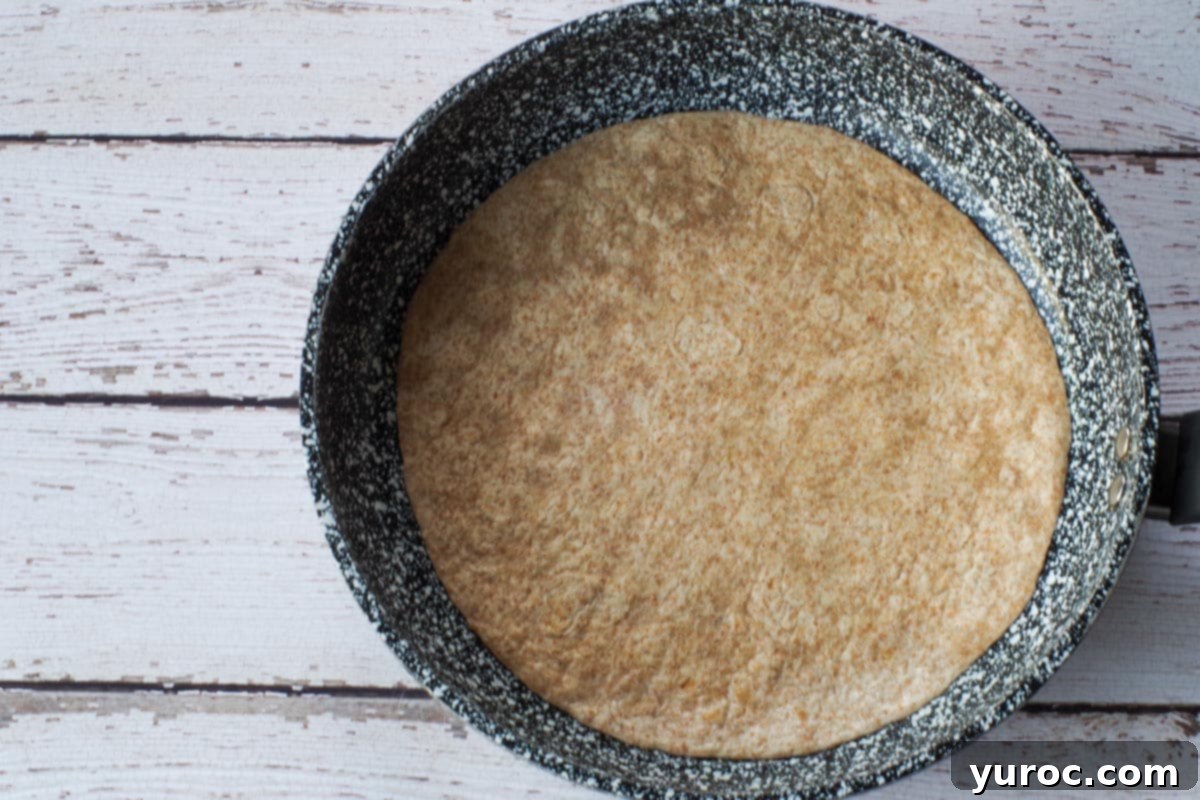 Quick Rotisserie Chicken Quesadillas 5 Tortilla being heated in frying pan/skillet.