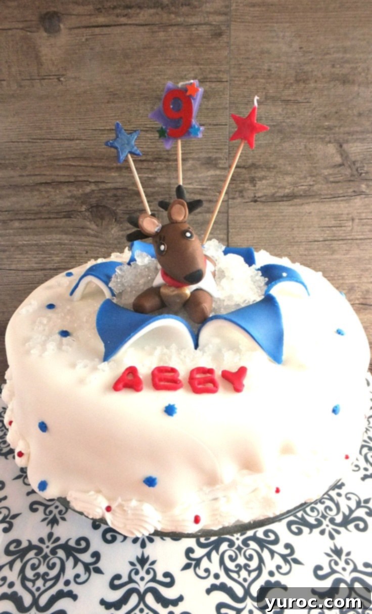 Beautifully decorated vanilla birthday cake with fondant elements for a 'Christmas in July' theme