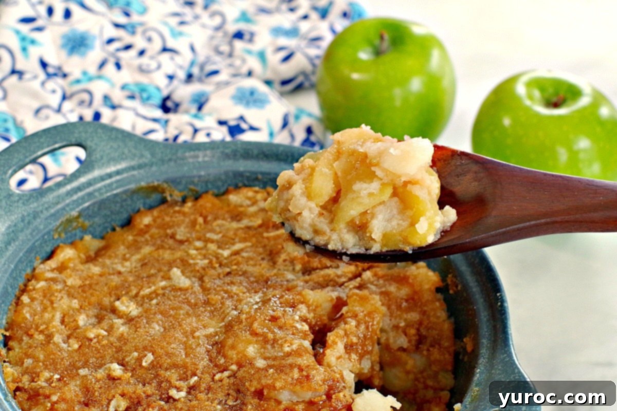 Golden Turnip Apple Bake 2 turnip and apple casserole (weight watchers friendly in a blue casserole dish, being held up on a wooden spoon with a green apple and blue patterned oven mitt in the background
