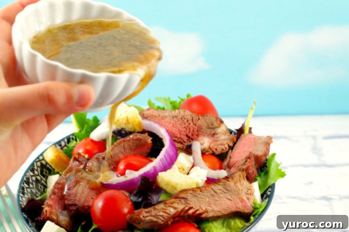 Moxie's Copycat Grilled Steak Salad with Clamato dressing being poured on top of fresh ingredients