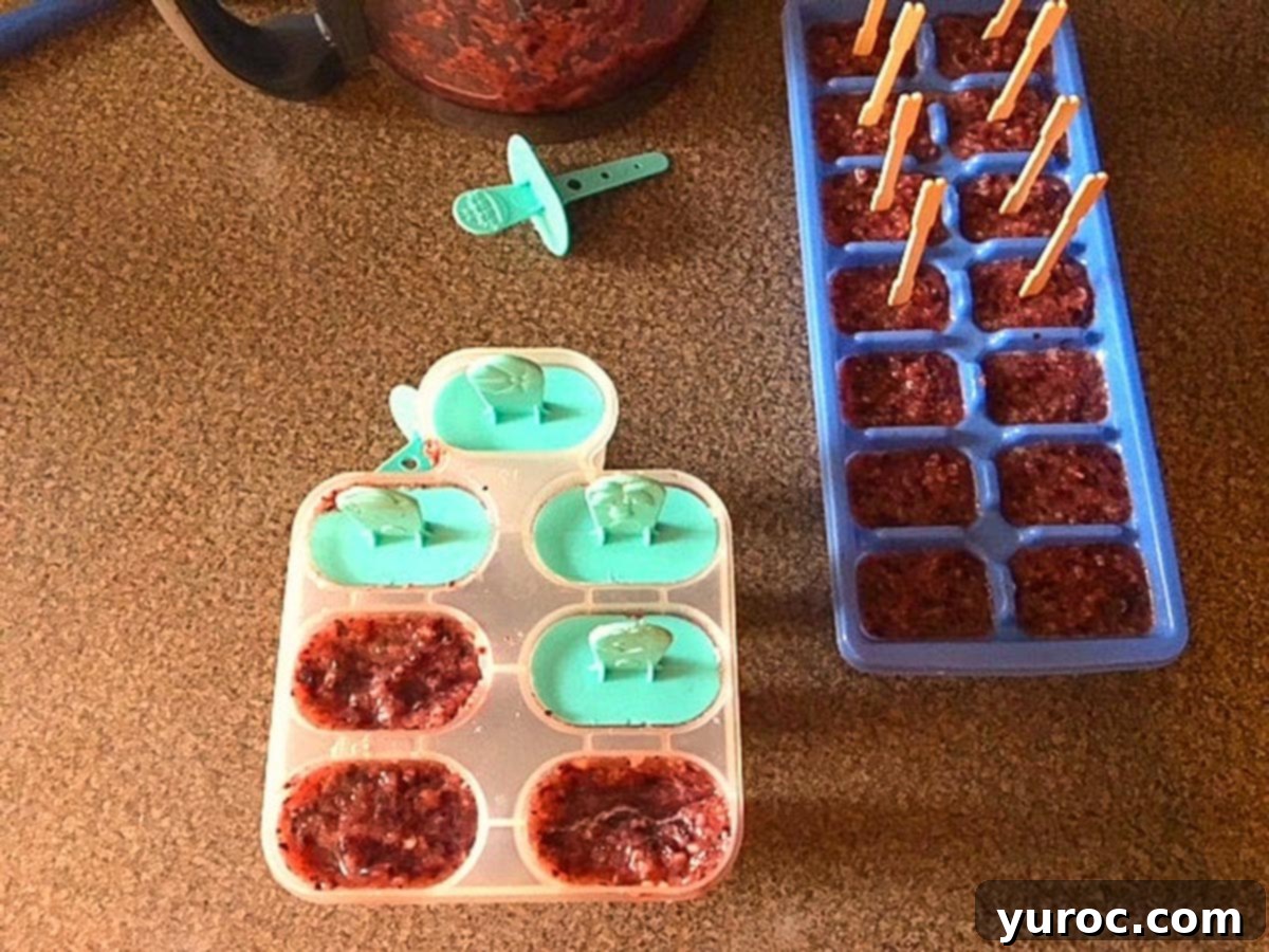 Popsicles freezing in both traditional popsicle molds and ice cube trays with toothpicks, illustrating versatile methods for making homemade fruit ice pops.