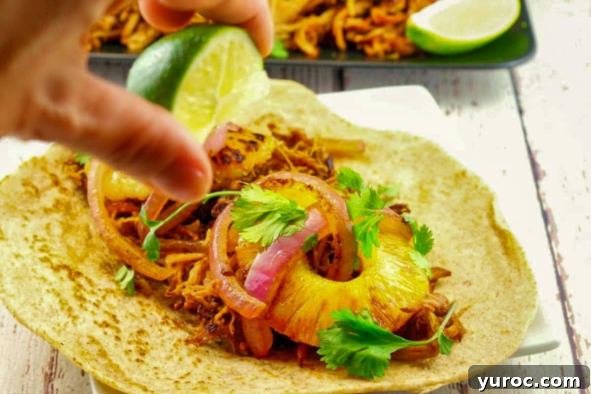 Crock Pot Pineapple Pork Carnita with lime being squeezed over it.