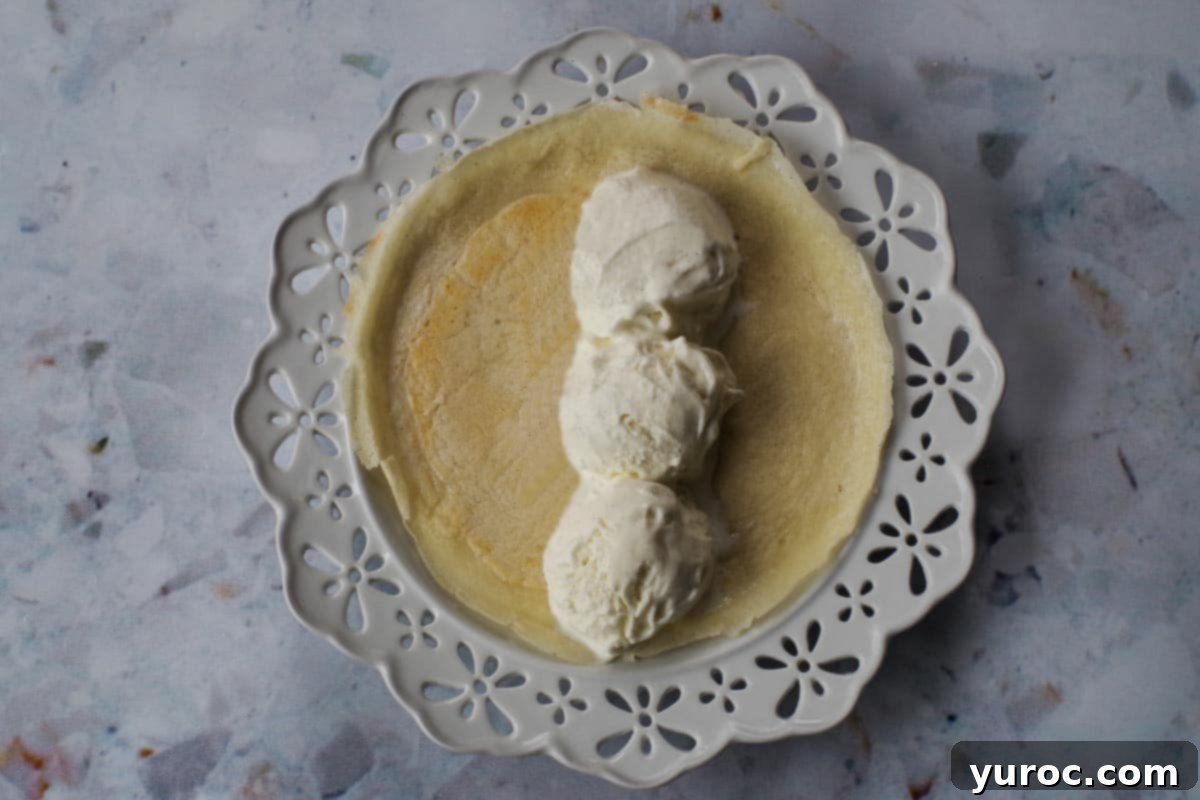 Crepe with three scoops of vanilla ice cream placed in the middle.