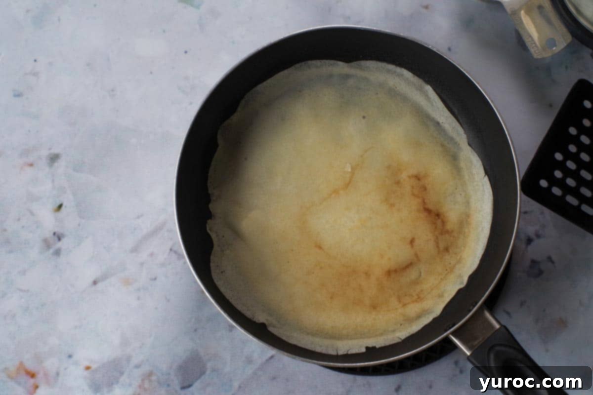 Birthday Cake Crepe flipped over in a frying pan.
