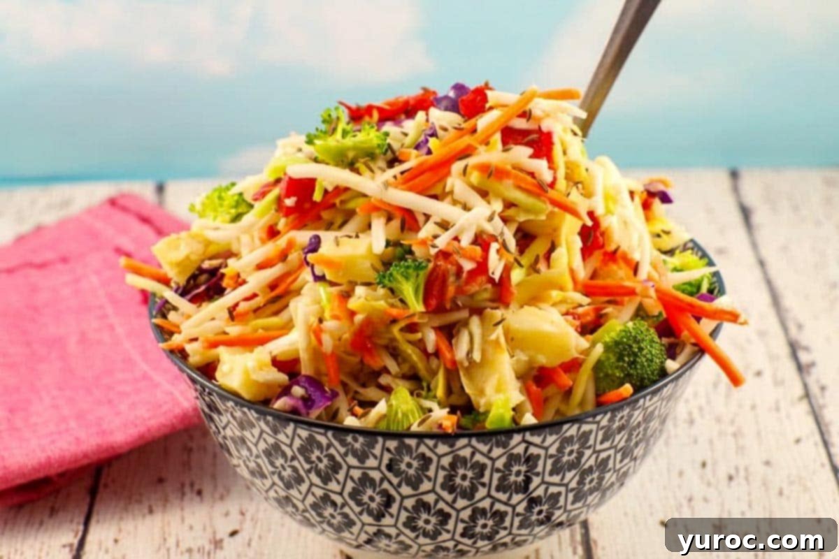 Zesty Artichoke Red Bell Pepper Slaw 2 Healthy coleslaw in a black and white patterned bowl with a spoon sticking out of the coleslaw