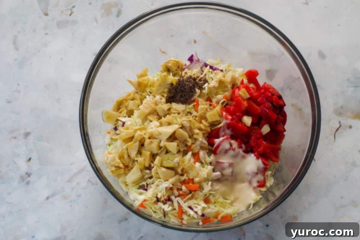Zesty Artichoke Red Bell Pepper Slaw 5 All Artichoke & Roasted Red Bell Pepper Coleslaw ingredients in a large glass bowl.