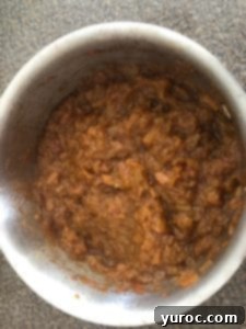 Cooked rhubarb compote, thickened and tender, in a saucepan, ready for the final step.